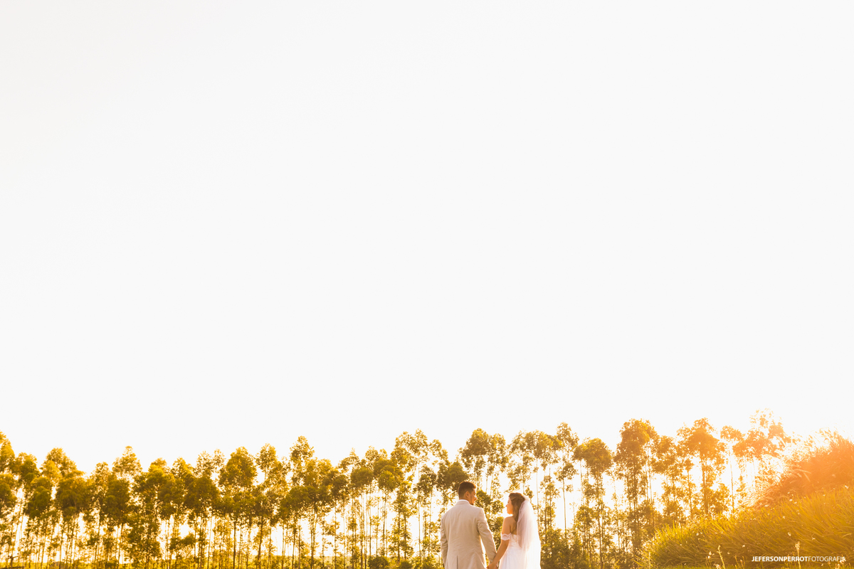 casal em meio a gramado verde em um lindo por-do-sol