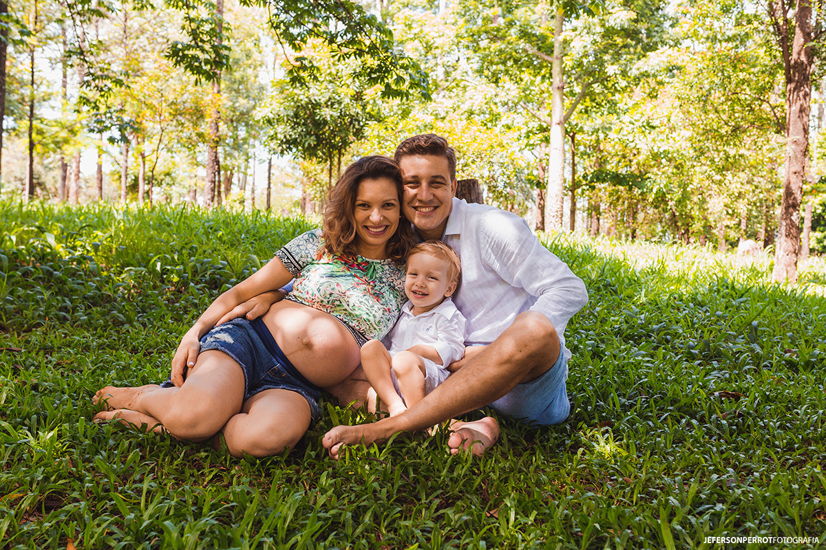 família sentada em parque maringaense