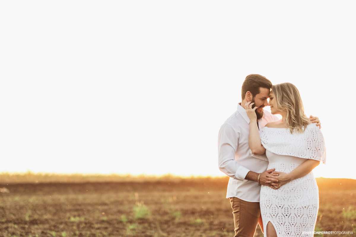 casal em plantação colhida de soja durante o por do sol em mandaguari parana
