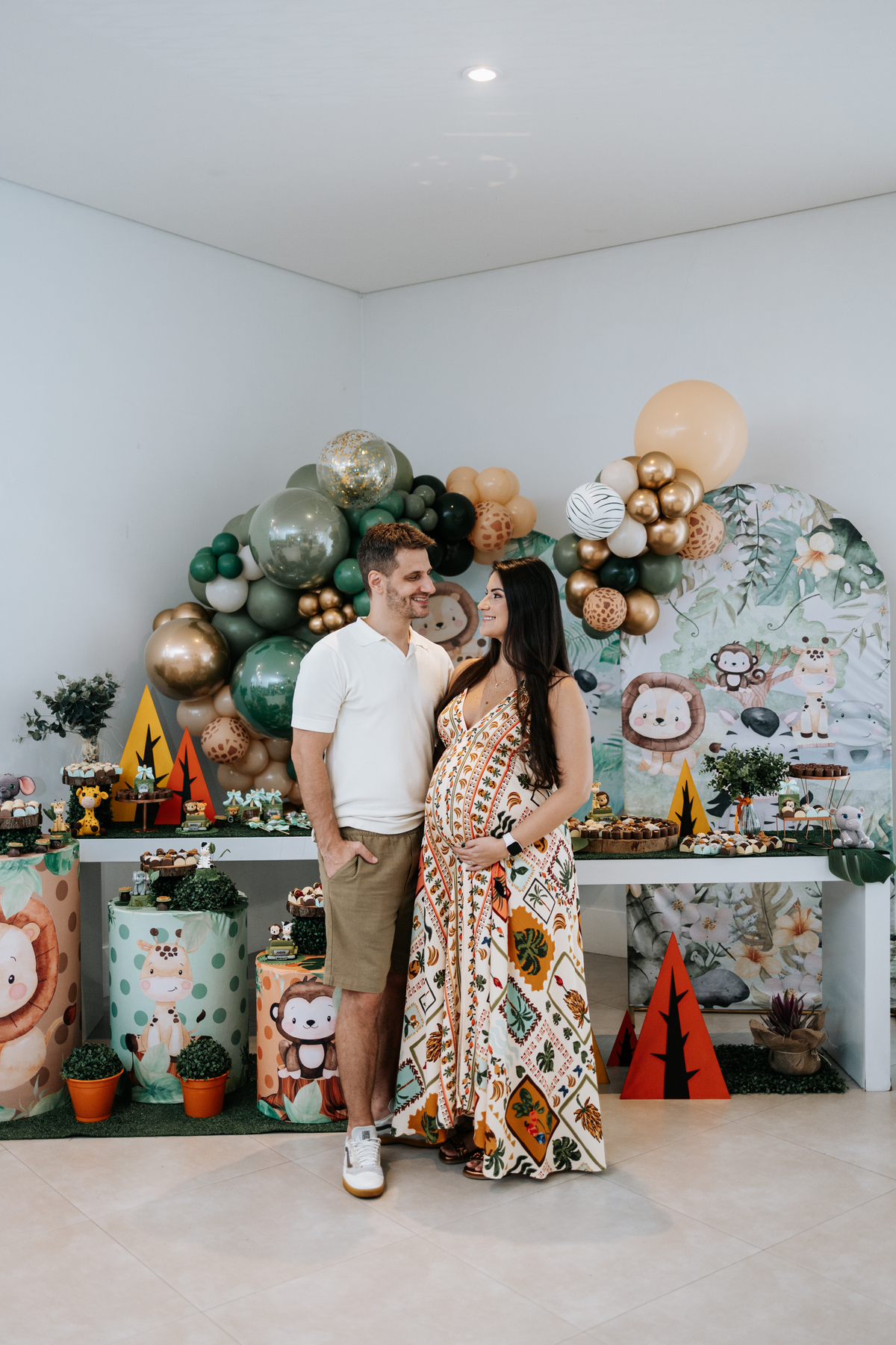 Foto do casal sorridente posando em frente à mesa de doces.