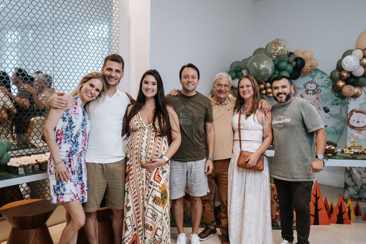 Foto de grupo com convidados sorridentes ao lado da mesa temática.