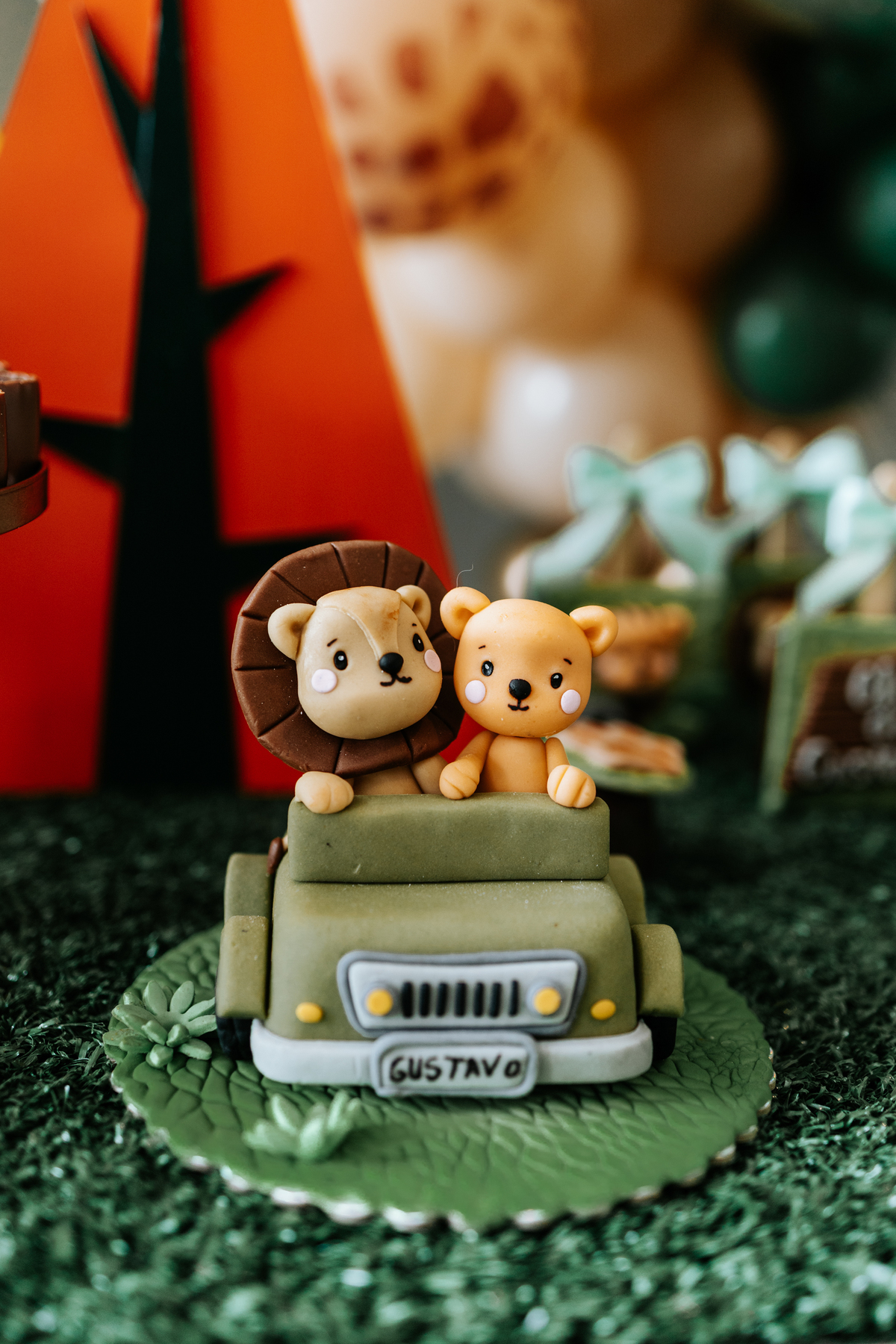 Foto aproximada de doces personalizados com leão e urso safari.