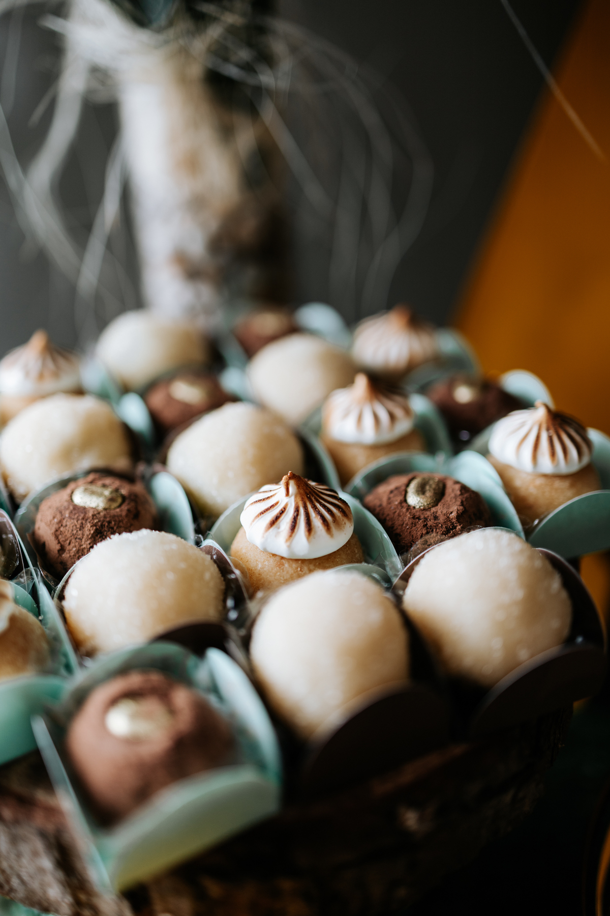 Foto em close de bandeja com brigadeiros gourmet e docinhos finos.