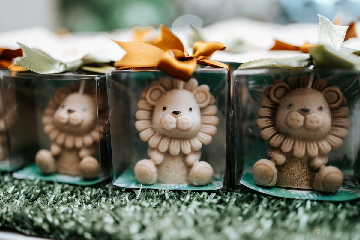 Foto de lembrancinhas em caixinhas transparentes com leõezinhos de biscuit.