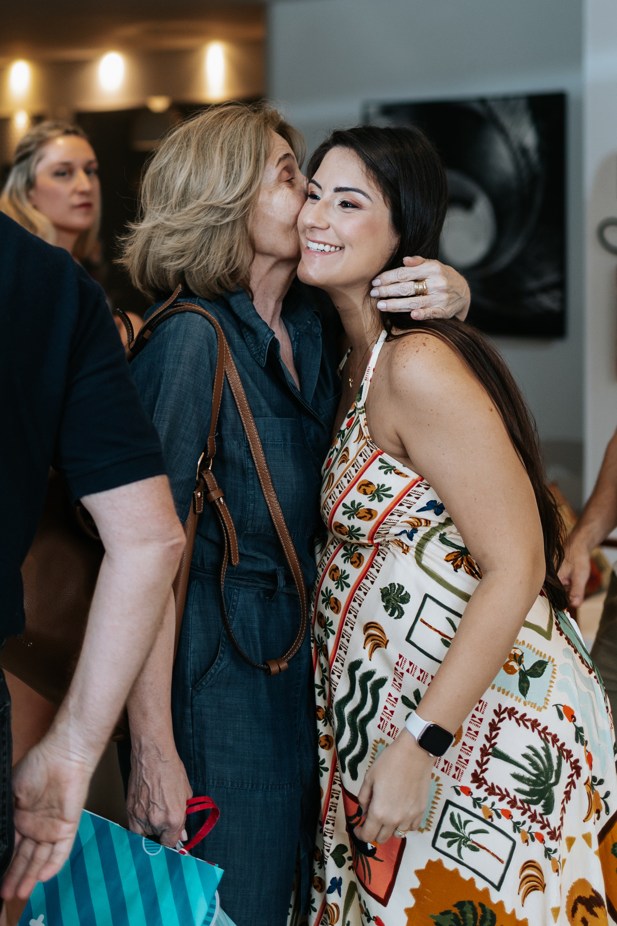 Foto da gestante recebendo um abraço e carinho de uma convidada.