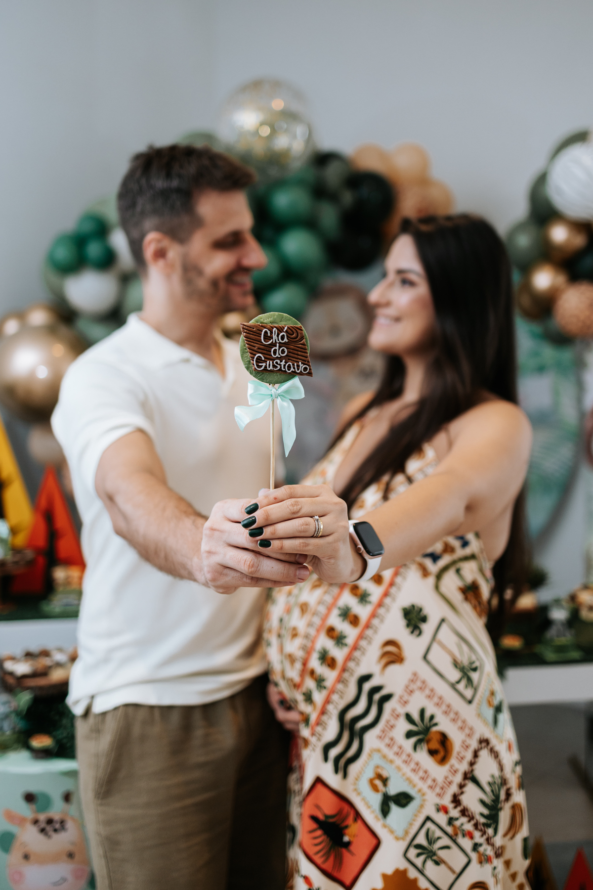 Foto do casal segurando um doce personalizado escrito 