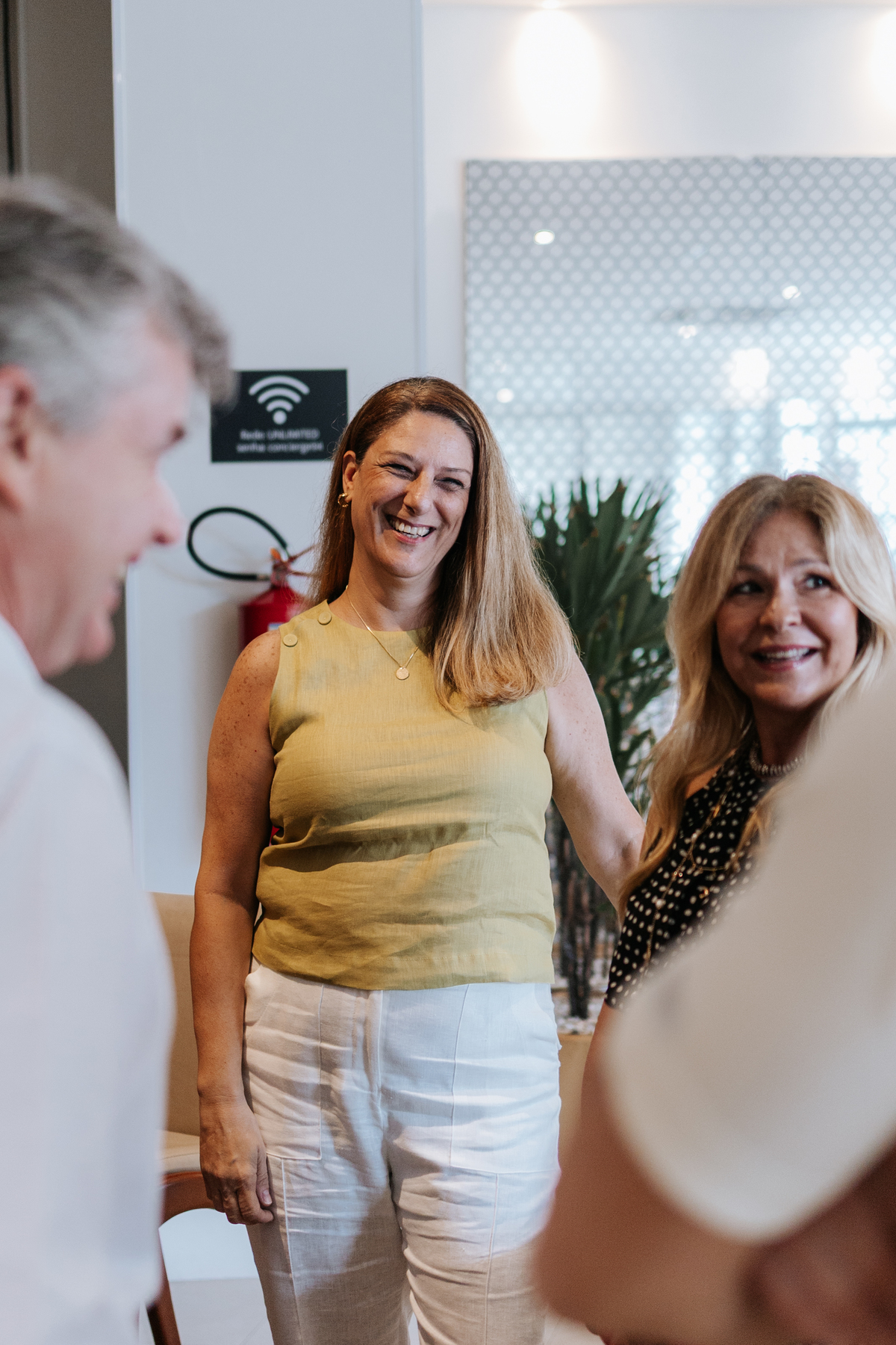 Foto de convidadas sorridentes conversando durante o evento.