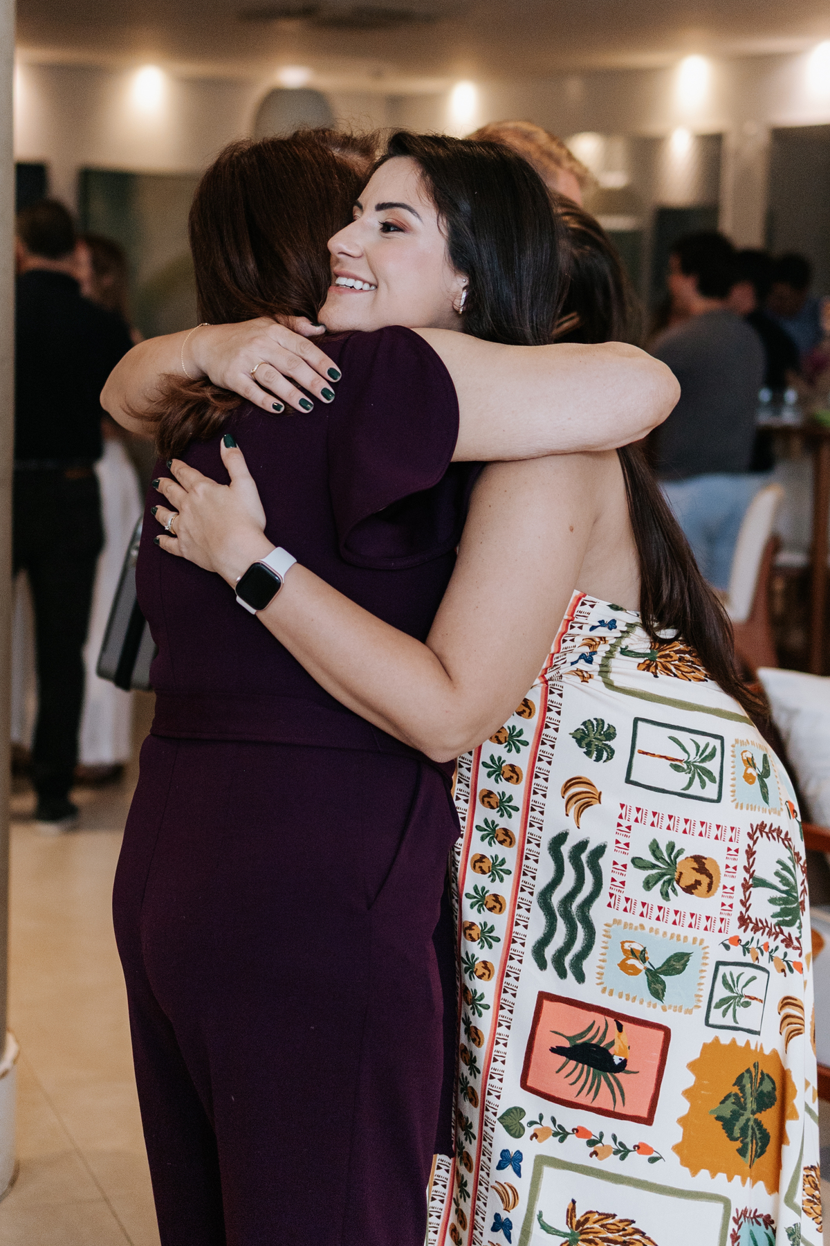 Foto de abraço apertado entre a gestante e uma convidada.