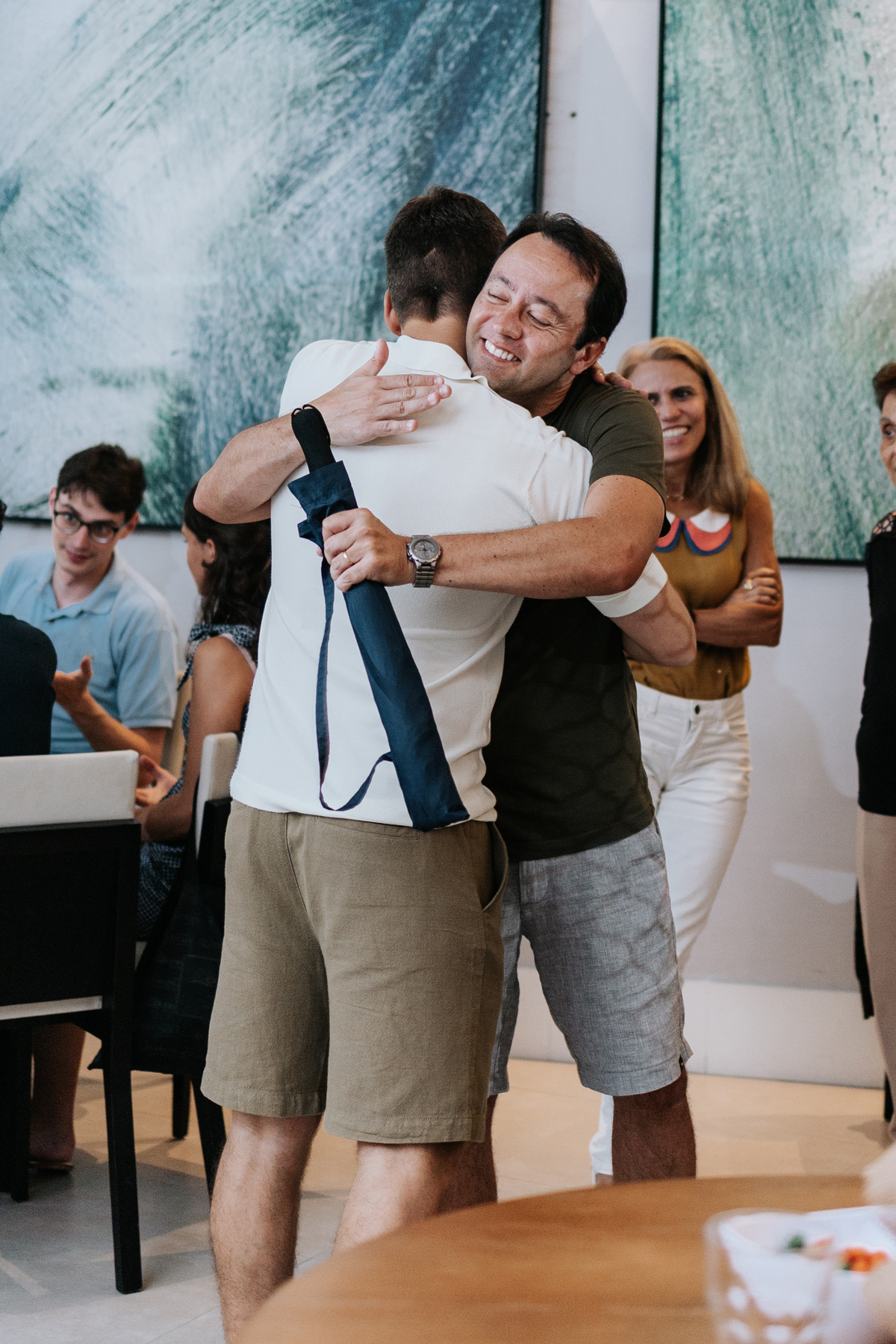Foto do futuro papai abraçando um amigo durante a festa.