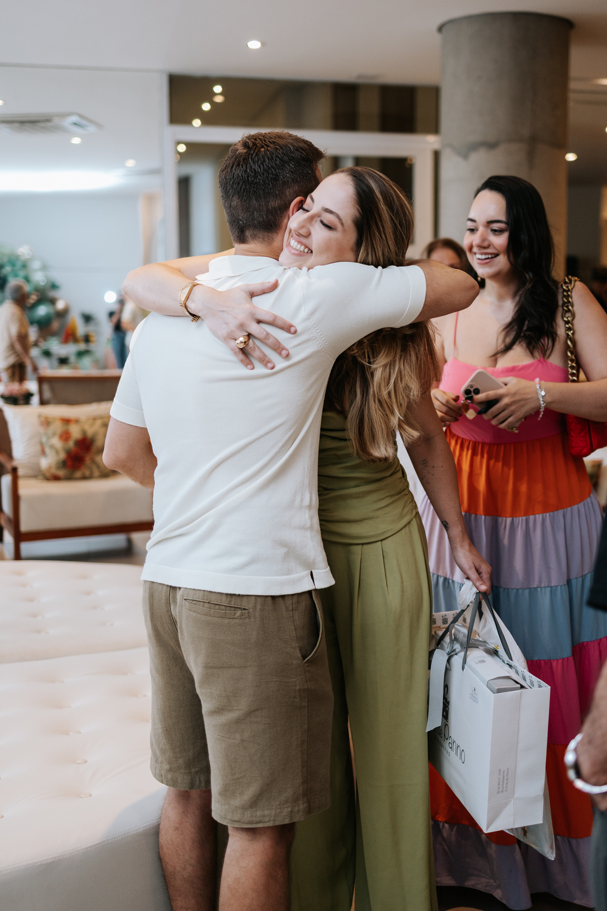 Foto de abraço coletivo entre amigos durante a comemoração.
