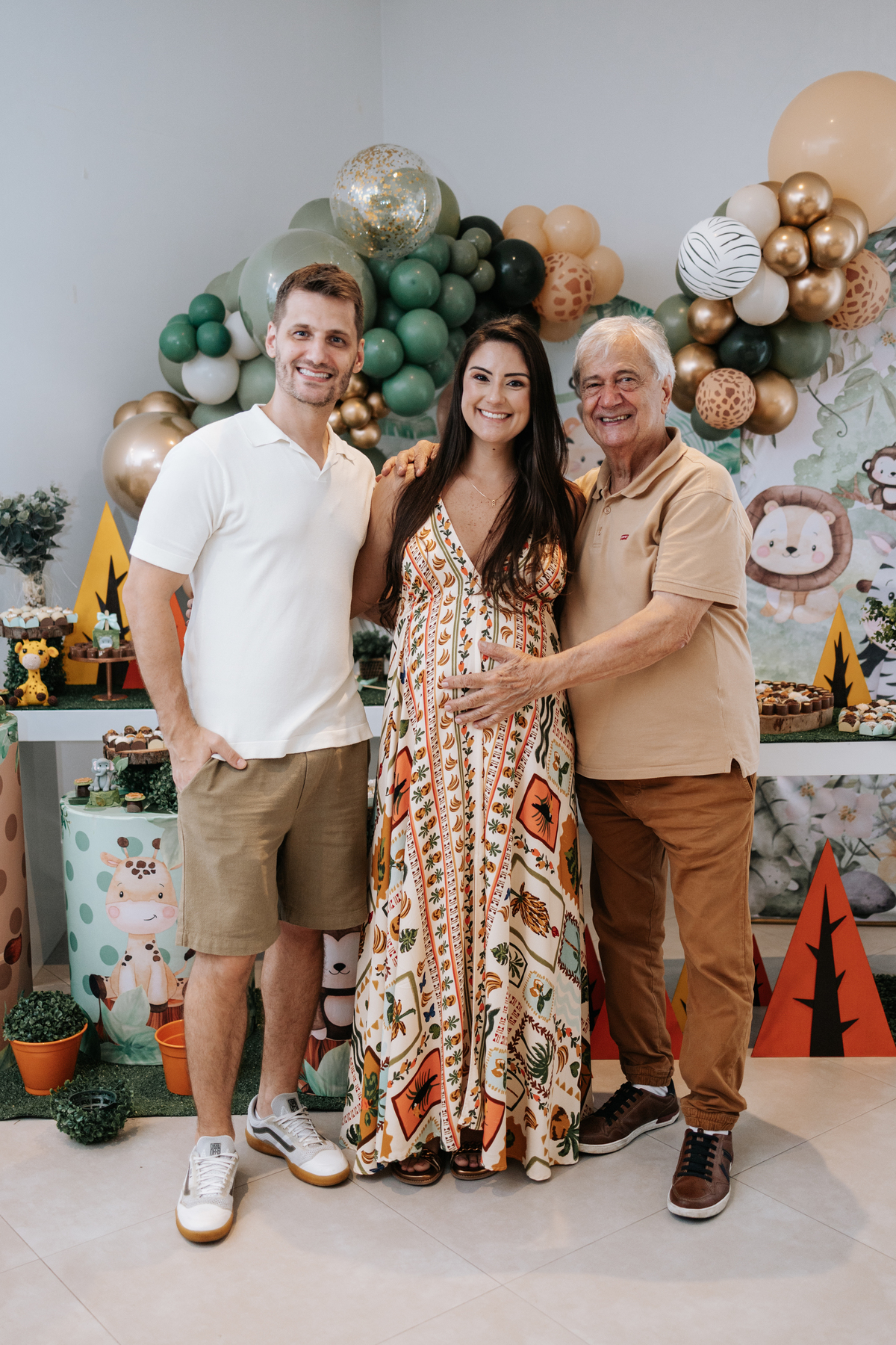 Foto oficial do casal com um familiar idoso em frente à mesa de doces.