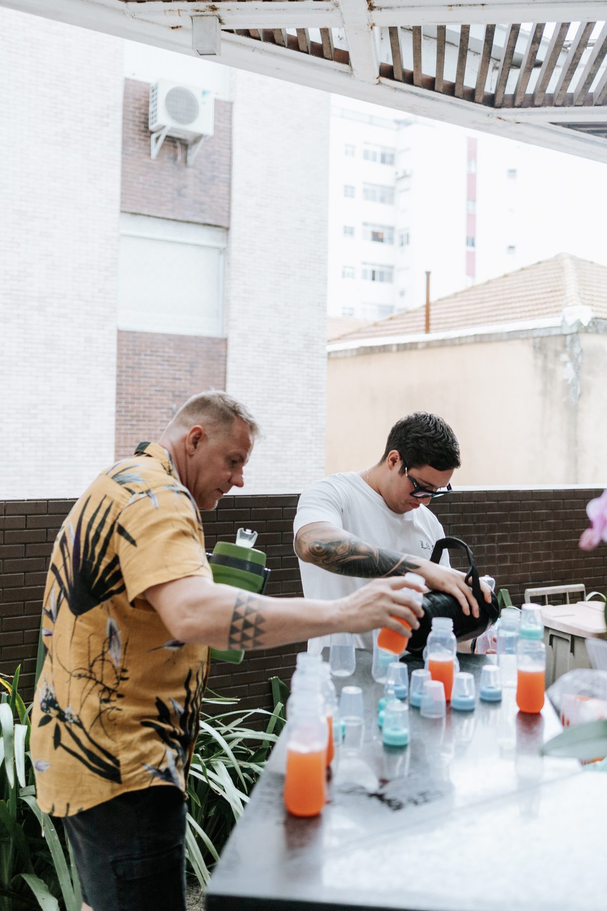 Foto de convidados se servindo de bebidas na área externa do salão.