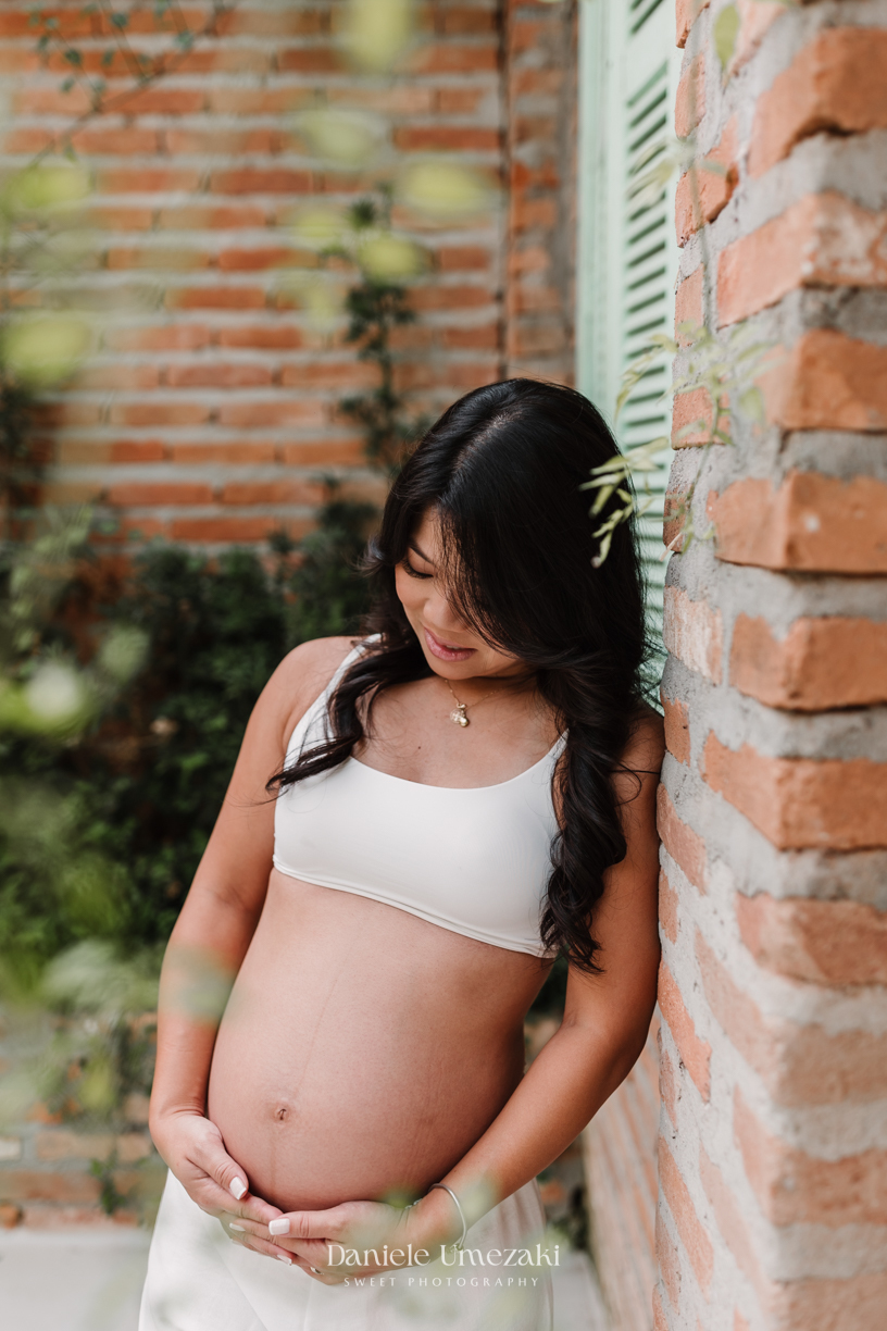 Ensaio gestante ao ar livre no Casarão La Villa, em Mogi das Cruzes, com a Vanessa e o Shige à espera da Lívia. Fotografia de gestante feita por Dani Umezaki, com luz suave, fotos naturais e registros afetivos desse momento especial.