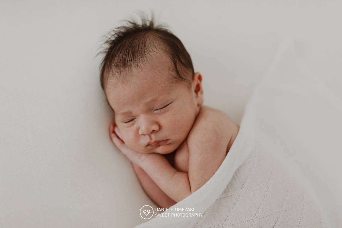 Fotografia de ensaio newborn em Mogi das Cruzes com o Benício, aos 17 dias de vida. Um registro feito com carinho, luz natural e cenário neutro, no estúdio da fotógrafa Dani Umezaki, pensado para o conforto e segurança do bebê e da família.