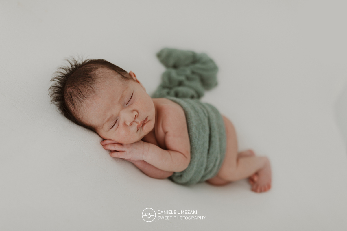 Fotografia de ensaio newborn em Mogi das Cruzes com o Benício, aos 17 dias de vida. Um registro feito com carinho, luz natural e cenário neutro, no estúdio da fotógrafa Dani Umezaki, pensado para o conforto e segurança do bebê e da família.