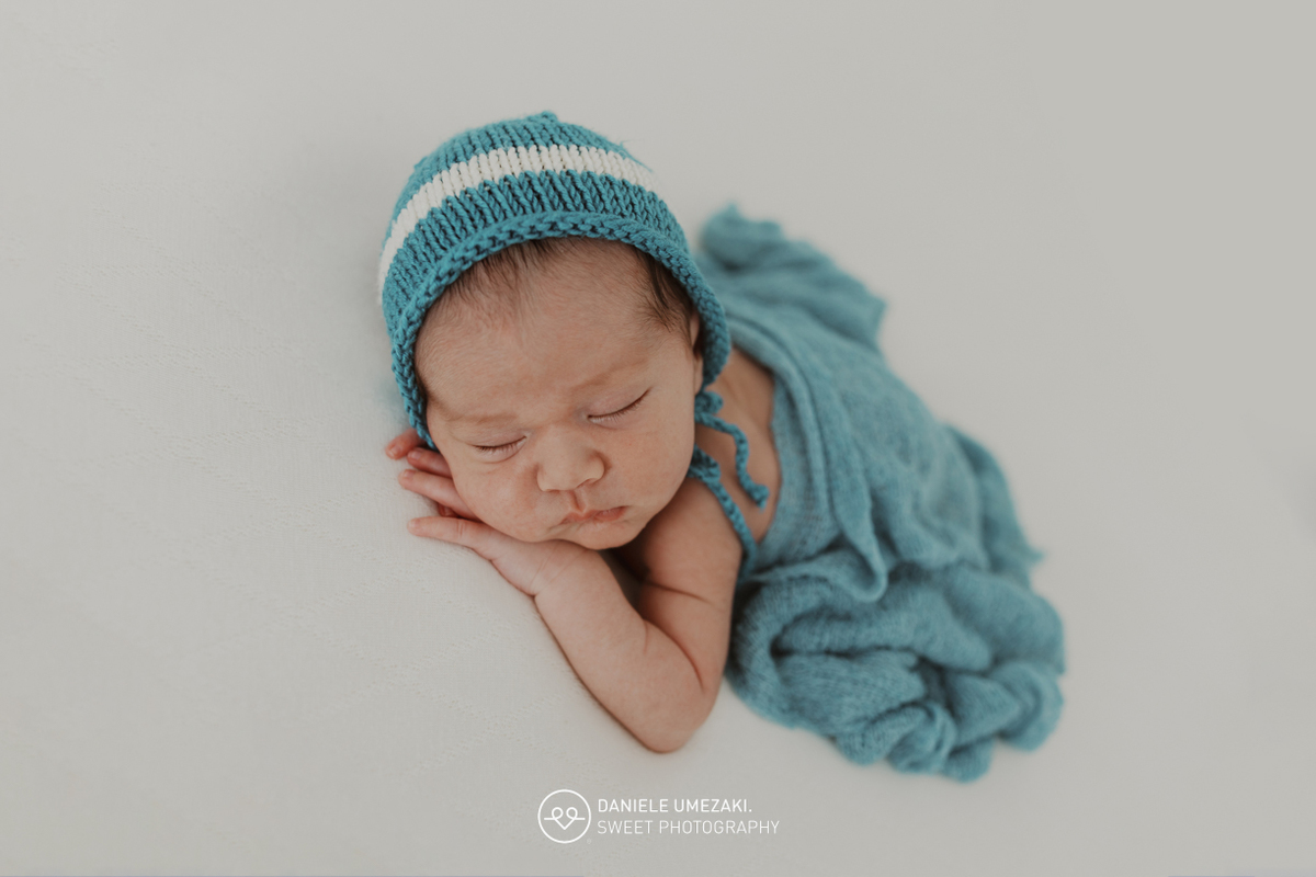 Fotografia de ensaio newborn em Mogi das Cruzes com o Benício, aos 17 dias de vida. Um registro feito com carinho, luz natural e cenário neutro, no estúdio da fotógrafa Dani Umezaki, pensado para o conforto e segurança do bebê e da família.