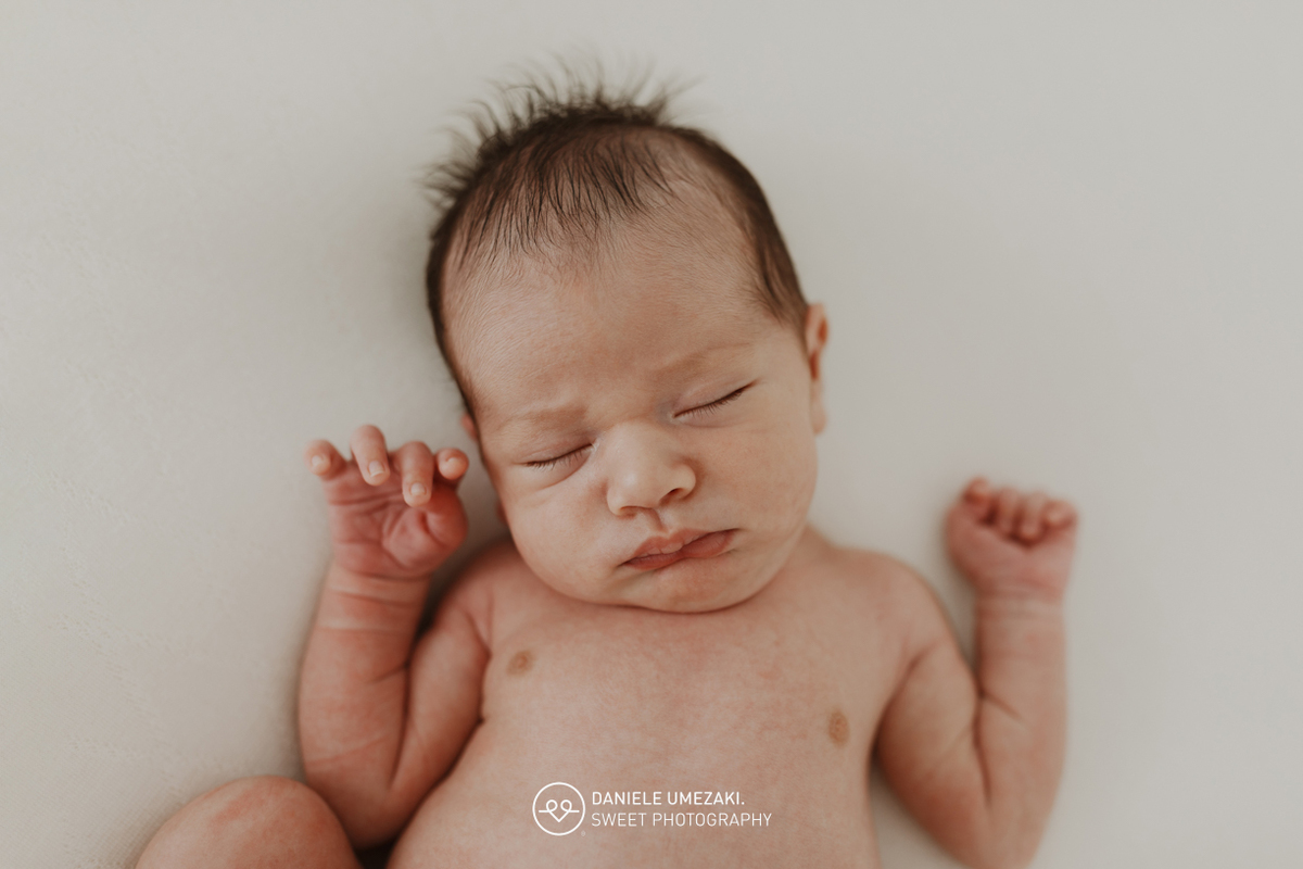 Fotografia de ensaio newborn em Mogi das Cruzes com o Benício, aos 17 dias de vida. Um registro feito com carinho, luz natural e cenário neutro, no estúdio da fotógrafa Dani Umezaki, pensado para o conforto e segurança do bebê e da família.