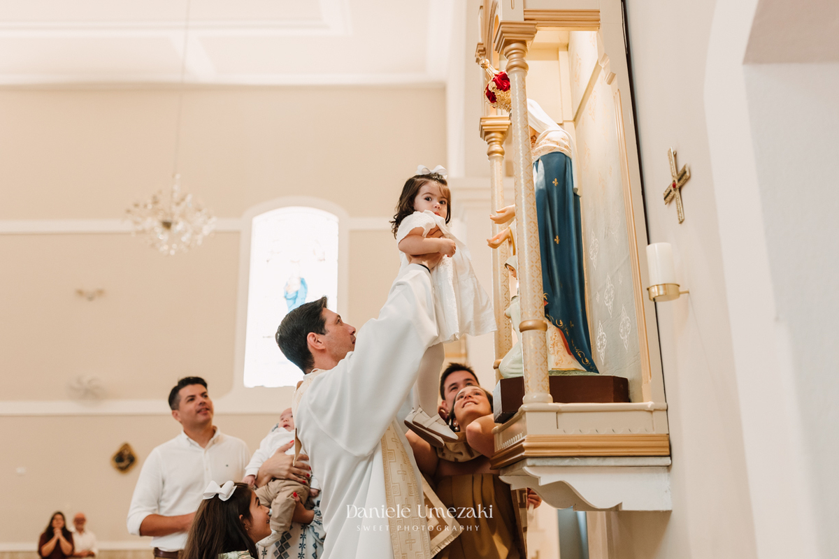 Fotografia de batizado em Mogi das Cruzes realizada por Dani Umezaki. Cerimônia da Malu e do Bernardo na Igreja do Socorro, com registros afetivos e cheios de significado. Família acompanhada desde o chá revelação e aniversários.