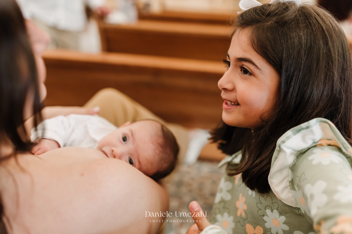 Fotografia de batizado em Mogi das Cruzes realizada por Dani Umezaki. Cerimônia da Malu e do Bernardo na Igreja do Socorro, com registros afetivos e cheios de significado. Família acompanhada desde o chá revelação e aniversários.