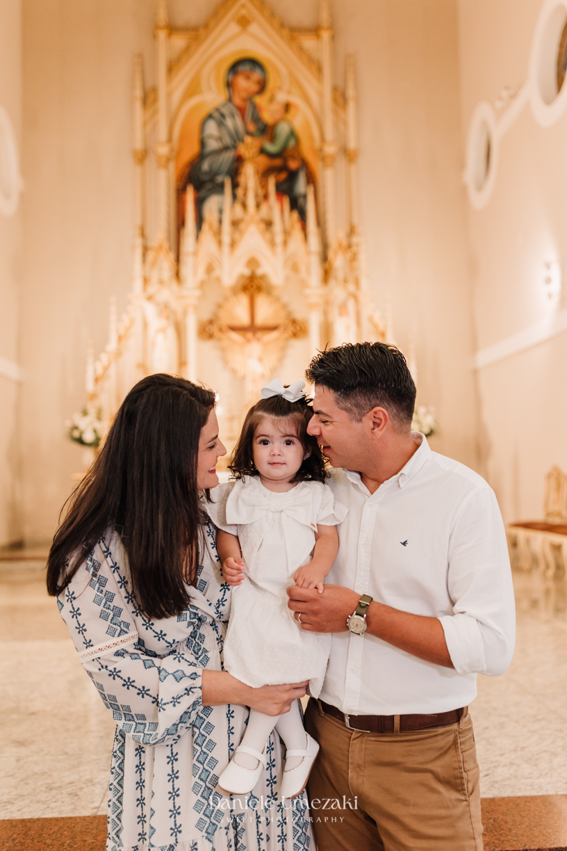 Fotografia de batizado em Mogi das Cruzes realizada por Dani Umezaki. Cerimônia da Malu e do Bernardo na Igreja do Socorro, com registros afetivos e cheios de significado. Família acompanhada desde o chá revelação e aniversários.