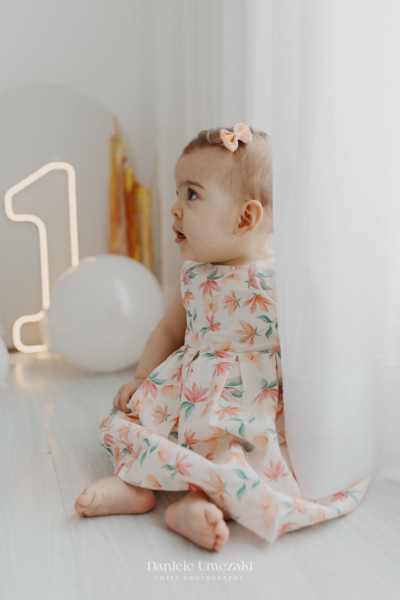 Smash the Cake da Olívia em estúdio de fotografia em Mogi das Cruzes. Ensaio delicado com bolo da @umedoces, papelaria da @jeh.scrap e luz natural. Um registro leve, doce e afetivo do primeiro aninho, feito por Dani Umezaki.