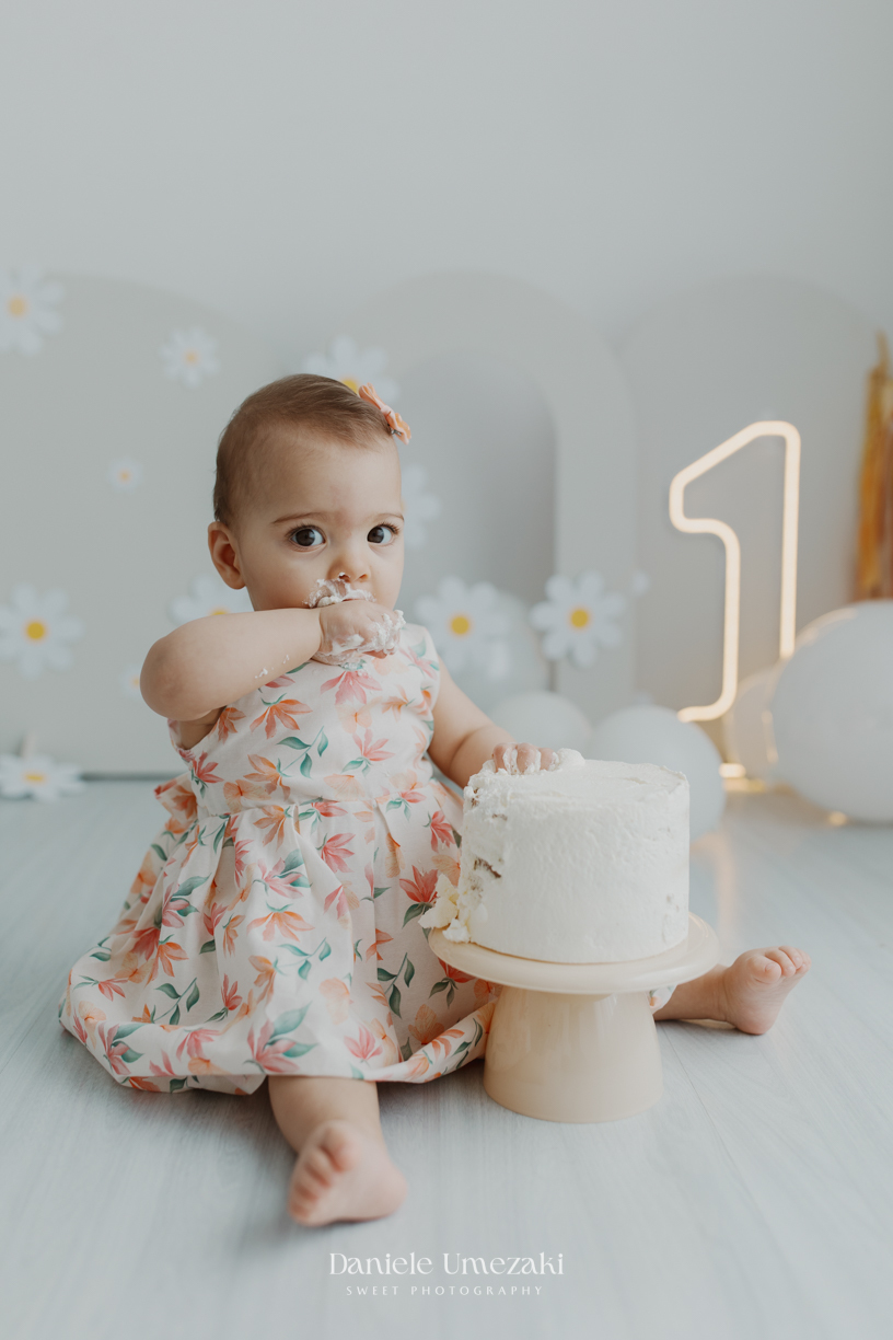 Smash the Cake da Olívia em estúdio de fotografia em Mogi das Cruzes. Ensaio delicado com bolo da @umedoces, papelaria da @jeh.scrap e luz natural. Um registro leve, doce e afetivo do primeiro aninho, feito por Dani Umezaki.