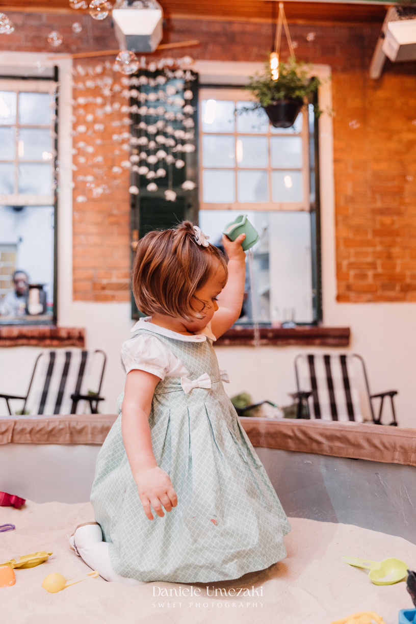 Fotografia de aniversário infantil em São Paulo. Festa intimista de 2 anos da Manuela no Quintal Decorinha, com bolinhas de sabão, pintura e caixa de areia. Registro leve e afetivo por Dani Umezaki