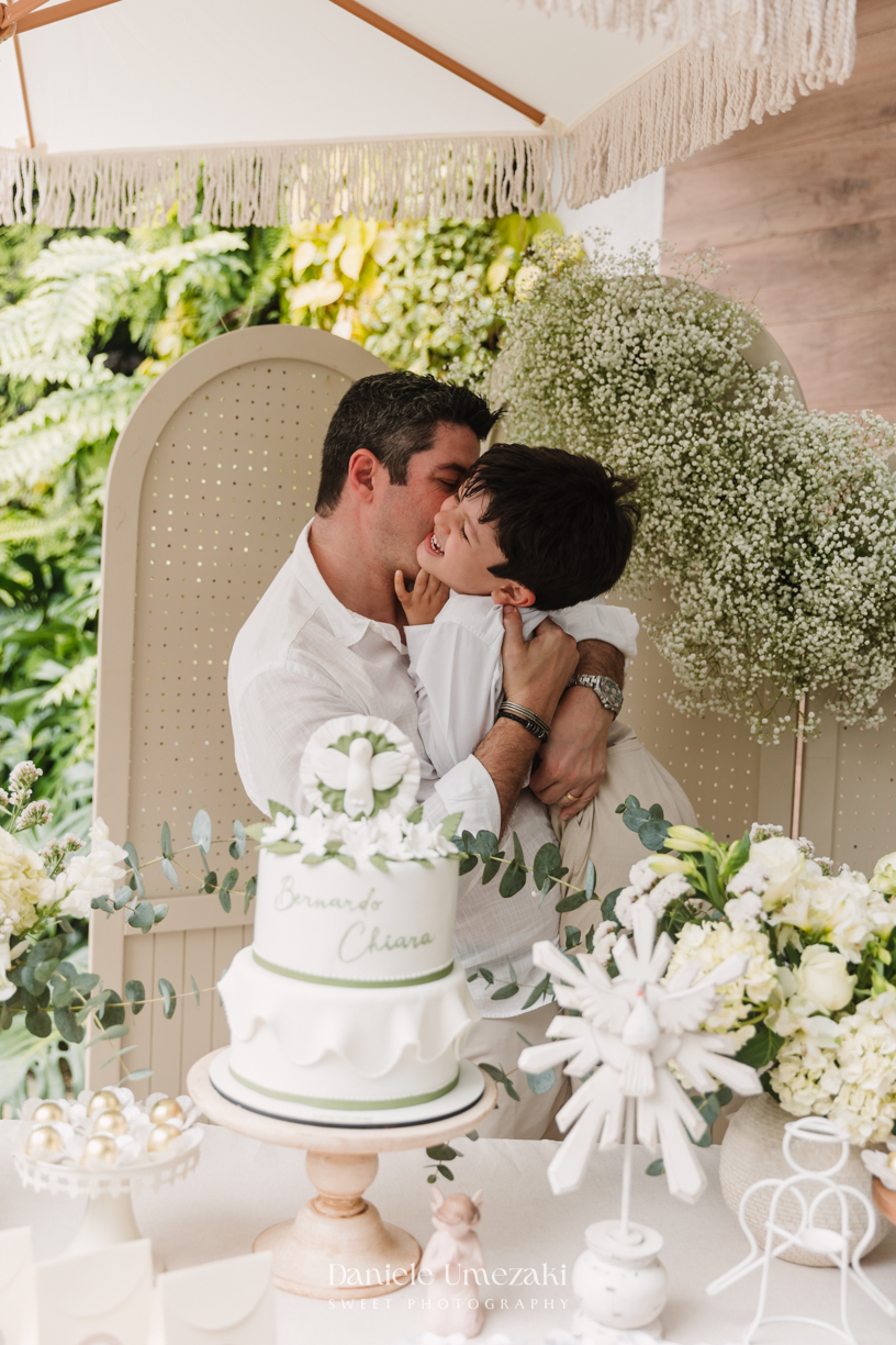 Fotografia de batizado na Igreja do Socorro, em Mogi das Cruzes. Cerimônia conduzida pelo Padre Michel, com almoço em família e decoração da Cerejeira Decora. Registro afetivo por Dani Umezaki