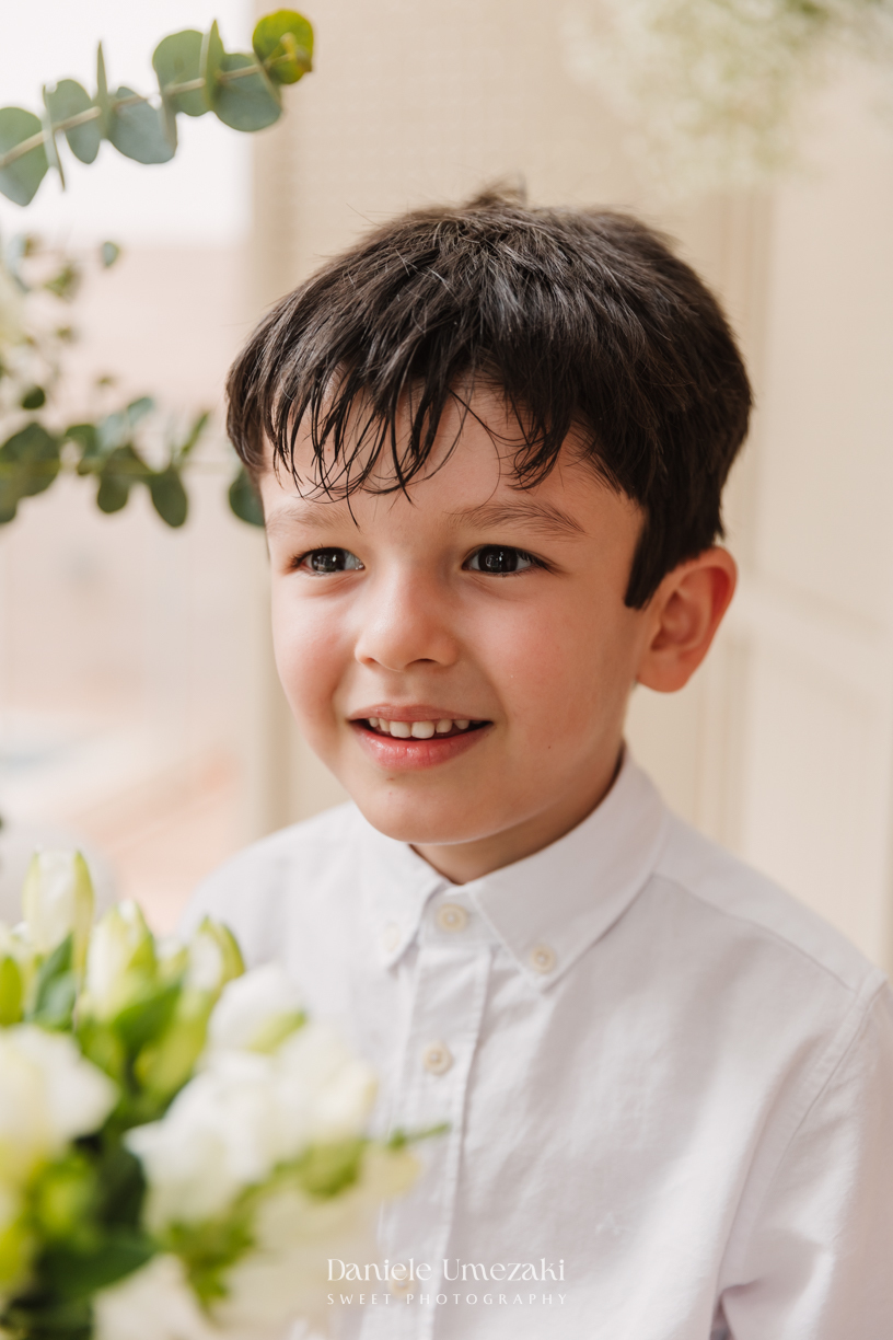 Fotografia de batizado na Igreja do Socorro, em Mogi das Cruzes. Cerimônia conduzida pelo Padre Michel, com almoço em família e decoração da Cerejeira Decora. Registro afetivo por Dani Umezaki