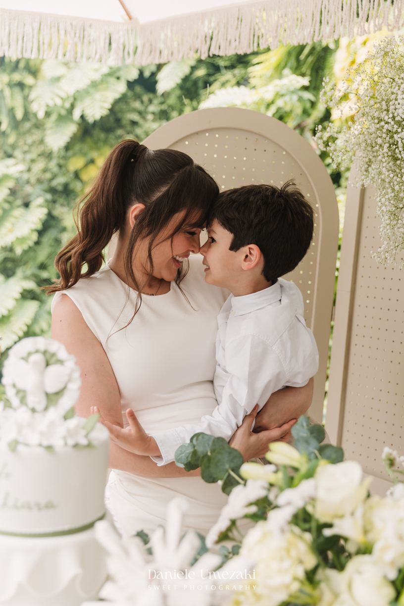 Fotografia de batizado na Igreja do Socorro, em Mogi das Cruzes. Cerimônia conduzida pelo Padre Michel, com almoço em família e decoração da Cerejeira Decora. Registro afetivo por Dani Umezaki