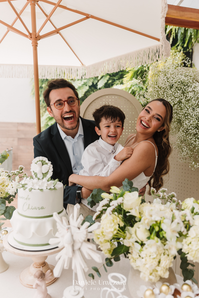 Fotografia de batizado na Igreja do Socorro, em Mogi das Cruzes. Cerimônia conduzida pelo Padre Michel, com almoço em família e decoração da Cerejeira Decora. Registro afetivo por Dani Umezaki