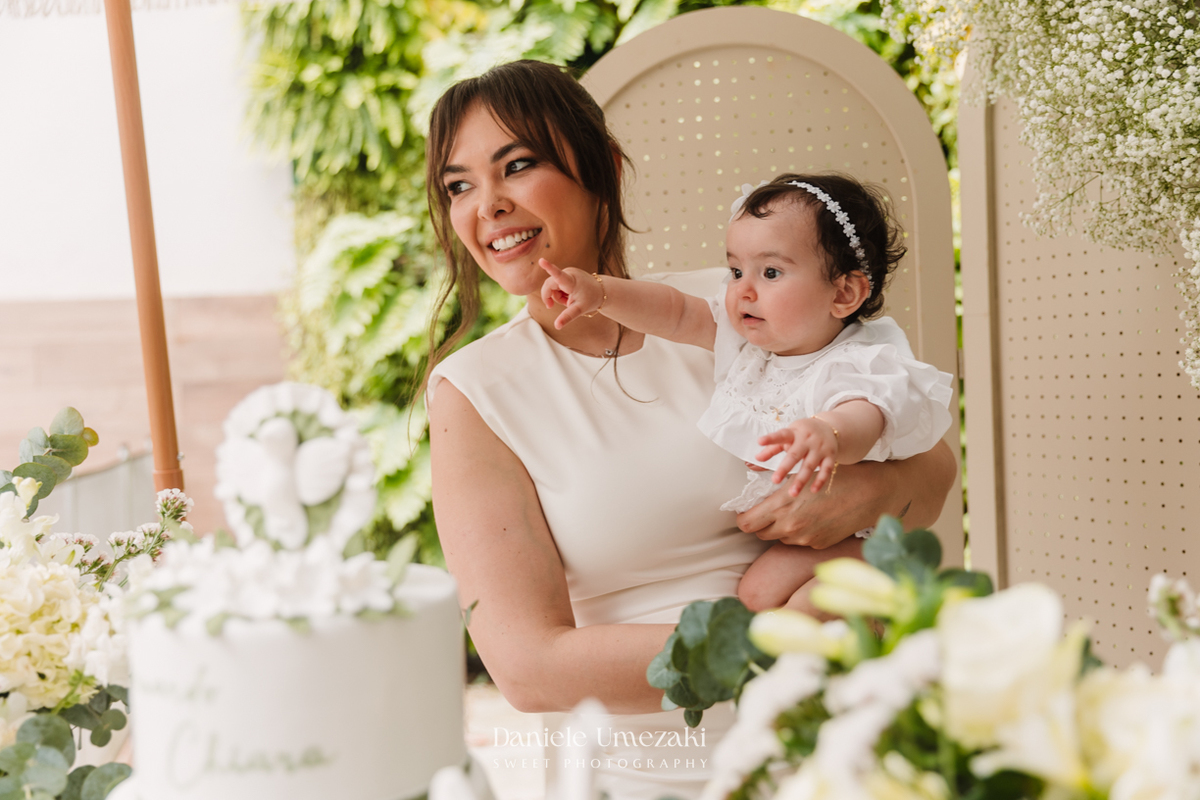 Fotografia de batizado na Igreja do Socorro, em Mogi das Cruzes. Cerimônia conduzida pelo Padre Michel, com almoço em família e decoração da Cerejeira Decora. Registro afetivo por Dani Umezaki