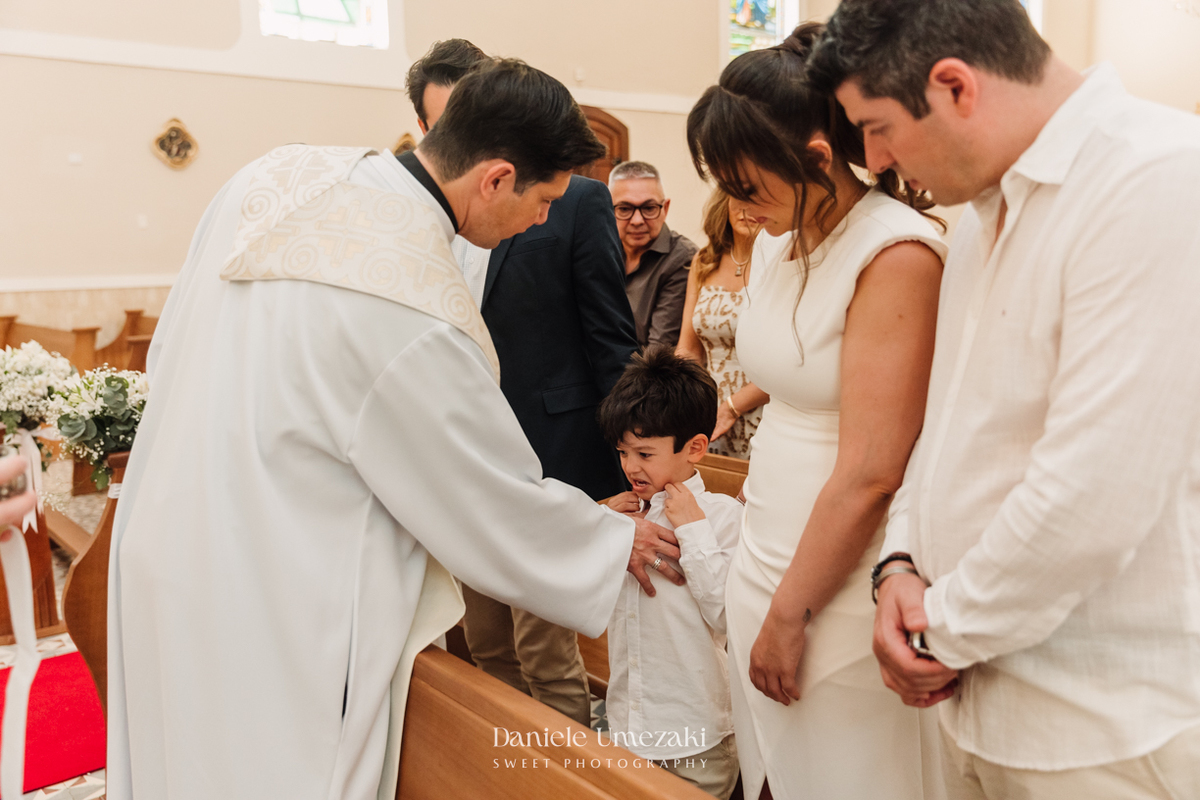 Fotografia de batizado na Igreja do Socorro, em Mogi das Cruzes. Cerimônia conduzida pelo Padre Michel, com almoço em família e decoração da Cerejeira Decora. Registro afetivo por Dani Umezaki