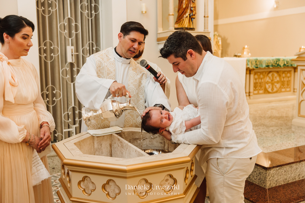 Fotografia de batizado na Igreja do Socorro, em Mogi das Cruzes. Cerimônia conduzida pelo Padre Michel, com almoço em família e decoração da Cerejeira Decora. Registro afetivo por Dani Umezaki