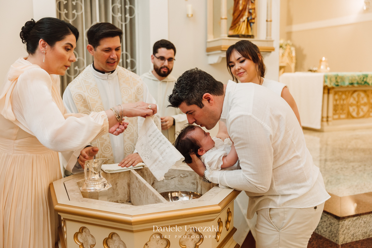 Fotografia de batizado na Igreja do Socorro, em Mogi das Cruzes. Cerimônia conduzida pelo Padre Michel, com almoço em família e decoração da Cerejeira Decora. Registro afetivo por Dani Umezaki