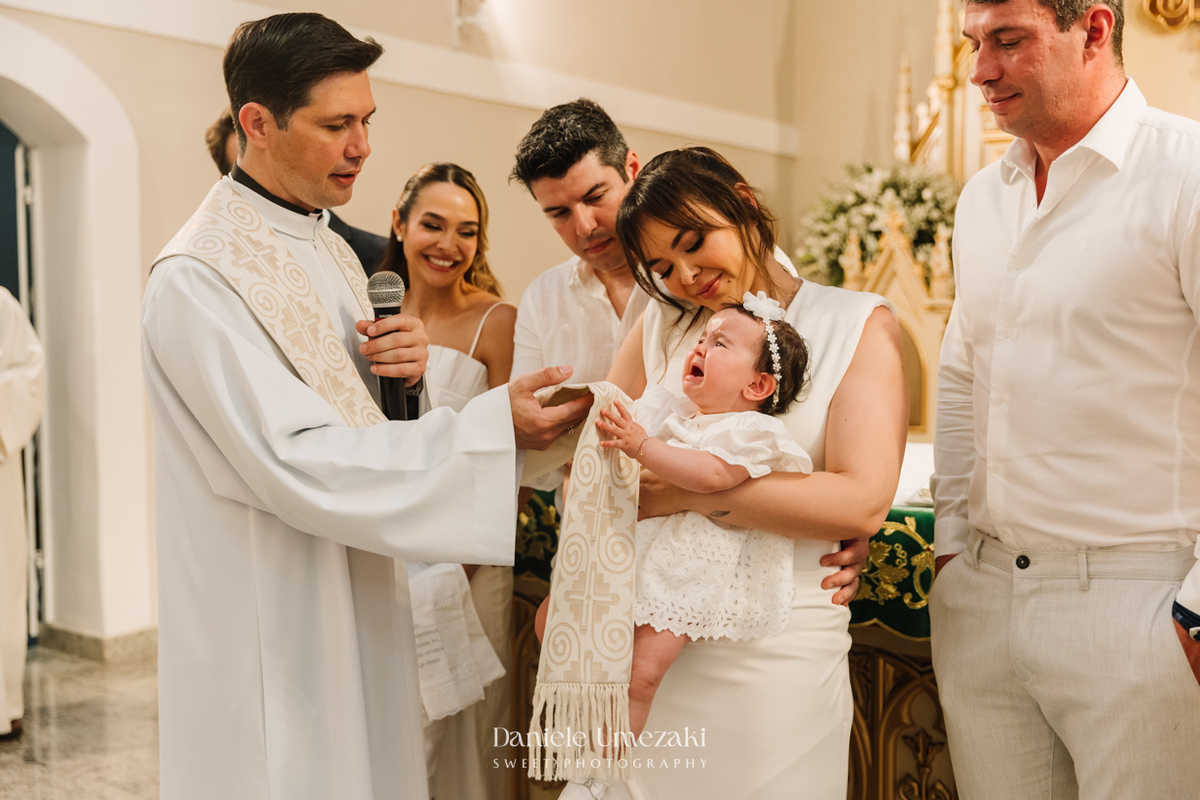 Fotografia de batizado na Igreja do Socorro, em Mogi das Cruzes. Cerimônia conduzida pelo Padre Michel, com almoço em família e decoração da Cerejeira Decora. Registro afetivo por Dani Umezaki