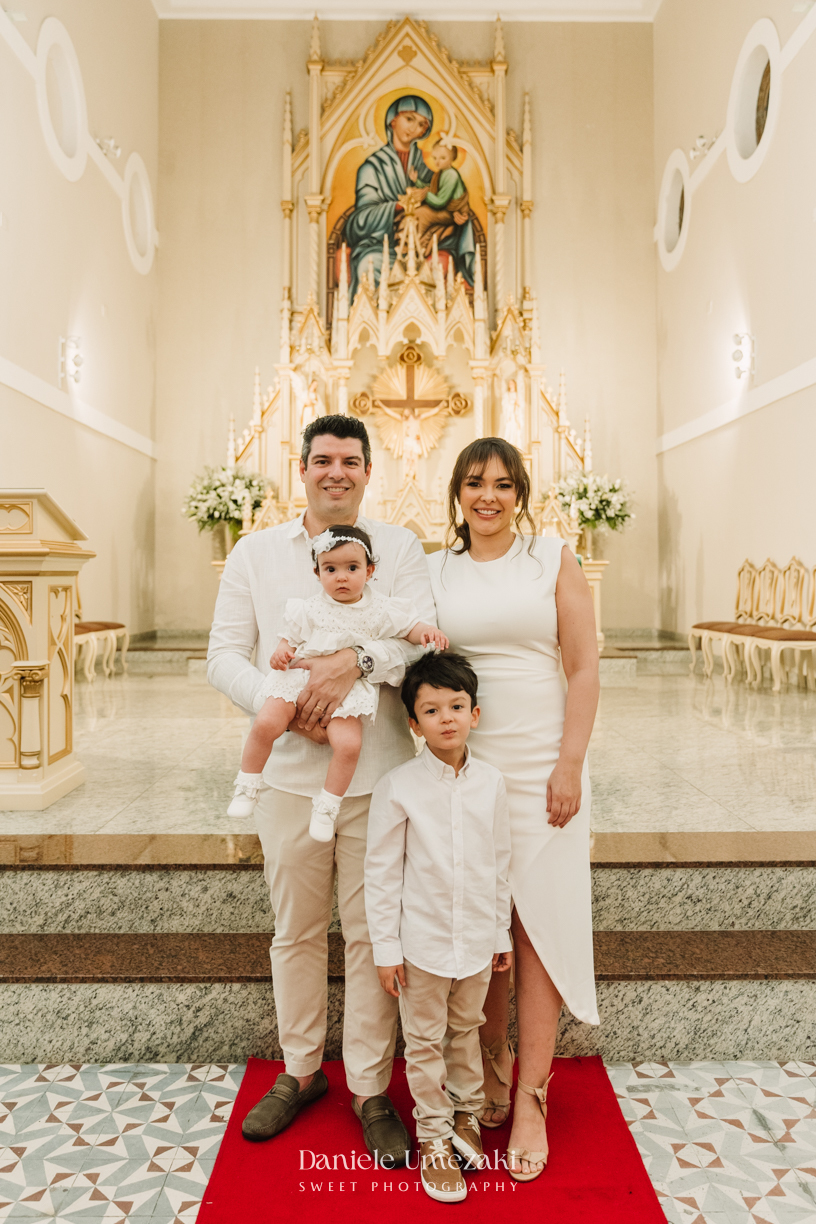 Fotografia de batizado na Igreja do Socorro, em Mogi das Cruzes. Cerimônia conduzida pelo Padre Michel, com almoço em família e decoração da Cerejeira Decora. Registro afetivo por Dani Umezaki
