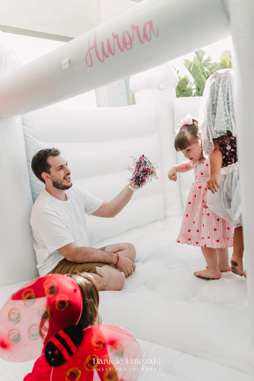 Aurora se divertindo com bolinhas de sabão durante seu aniversário de 2 anos. Fotografia de aniversário infantil em Mogi das Cruzes, com registros espontâneos e afetivos por Dani Umezaki