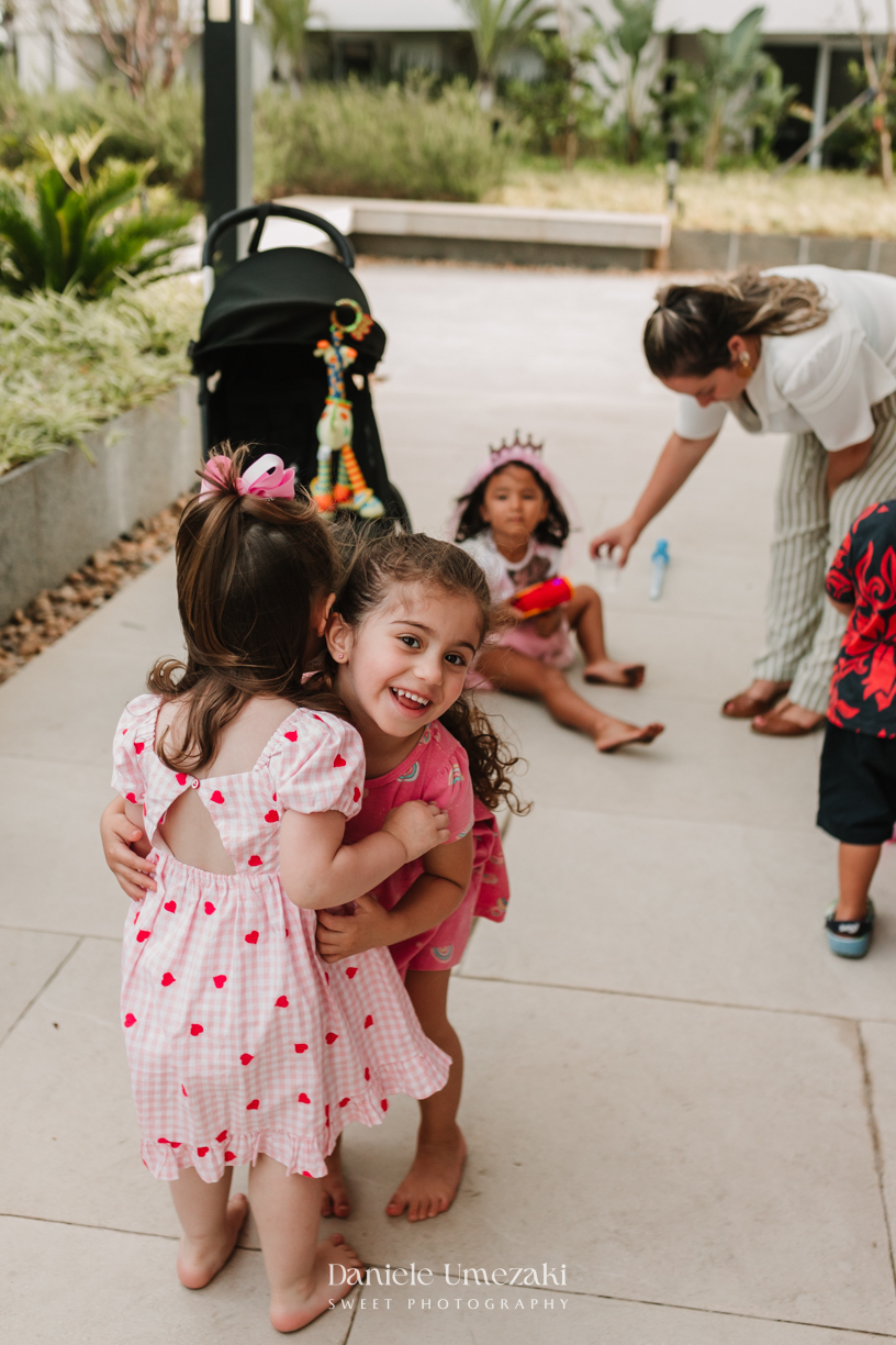 Aurora se divertindo com bolinhas de sabão durante seu aniversário de 2 anos. Fotografia de aniversário infantil em Mogi das Cruzes, com registros espontâneos e afetivos por Dani Umezaki.