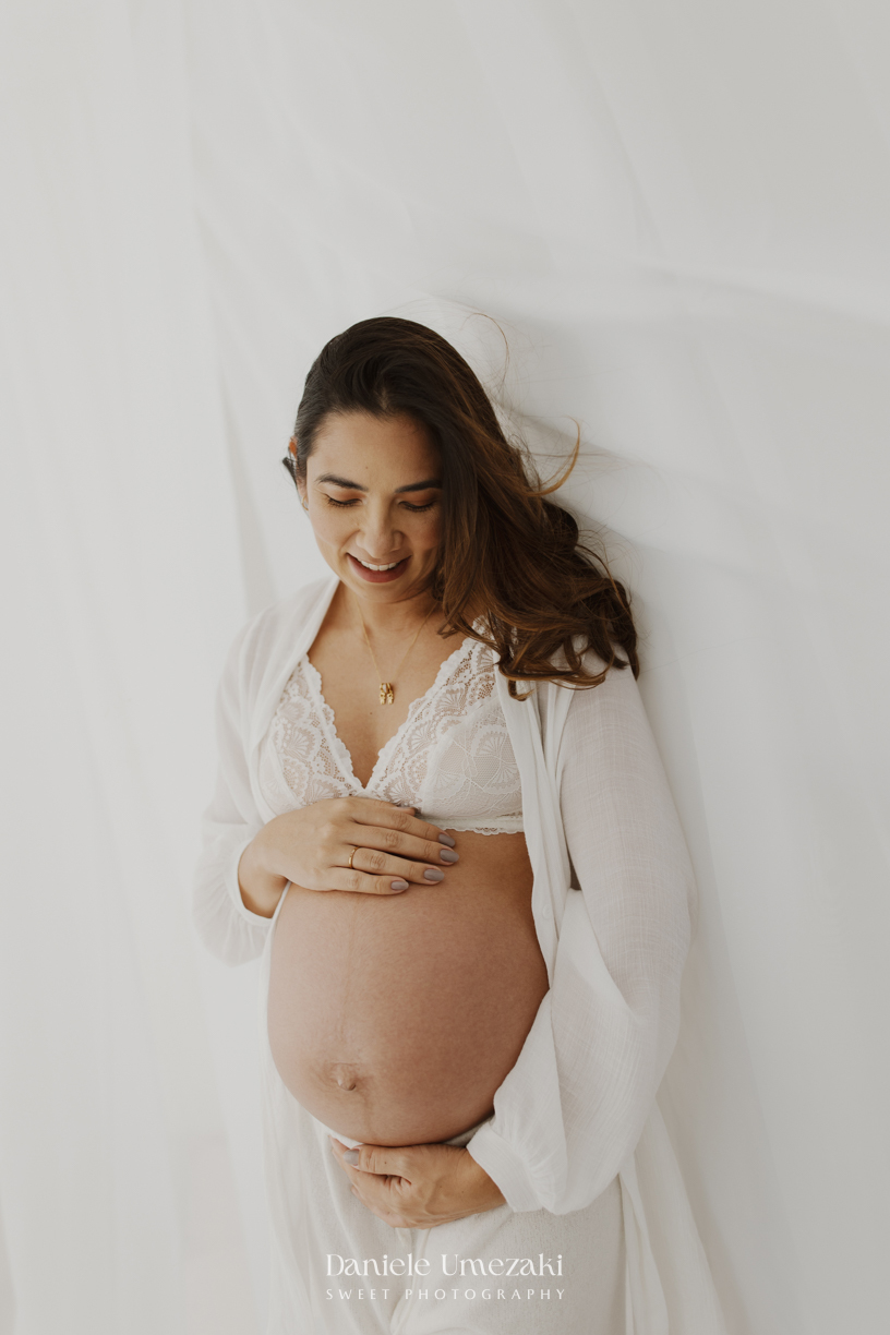 Ensaio gestante em estúdio em Mogi das Cruzes realizado por Dani Umezaki. Registros leves, naturais e atemporais da Bruna à espera do Arthur, valorizando a conexão da família e a beleza da gestação