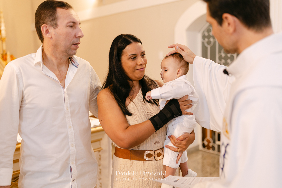 Batizado do Joaquim na Igreja do Socorro em Mogi das Cruzes, registrado por Dani Umezaki. Fotografias de batismo católico com foco na fé, na família e nos momentos mais emocionantes da celebração