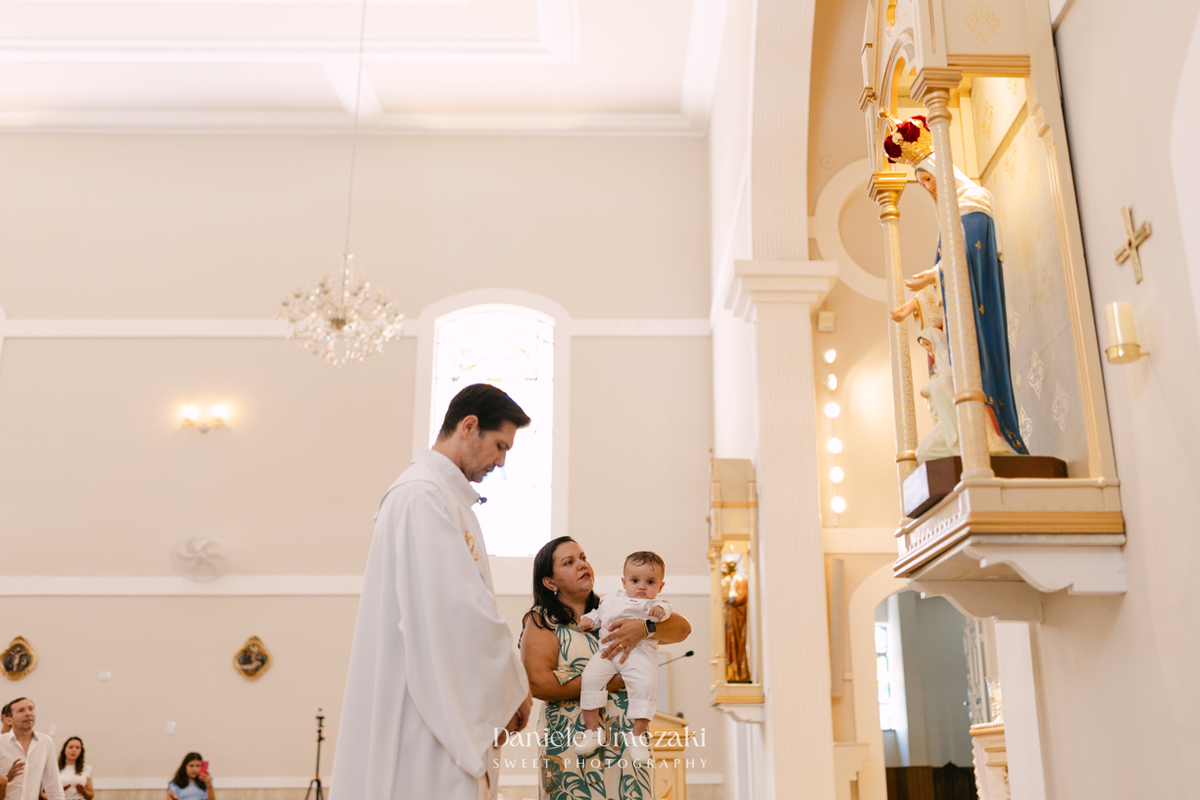 Batizado do Joaquim na Igreja do Socorro em Mogi das Cruzes, registrado por Dani Umezaki. Fotografias de batismo católico com foco na fé, na família e nos momentos mais emocionantes da celebração