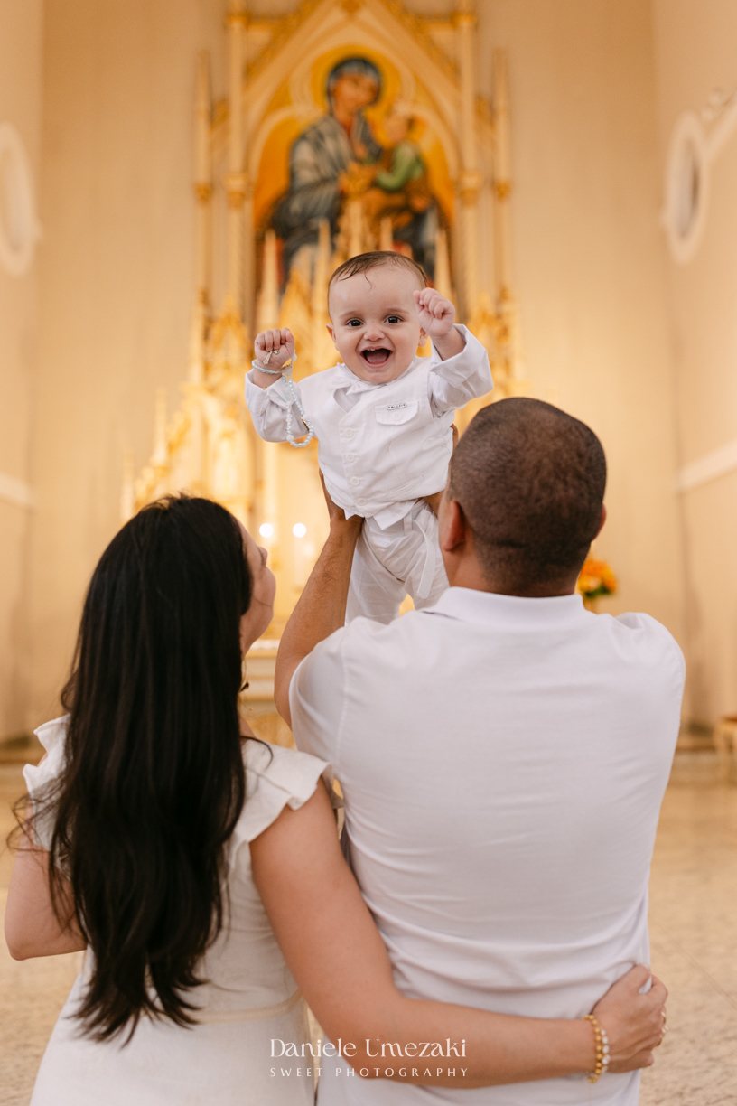 Batizado do Joaquim na Igreja do Socorro em Mogi das Cruzes, registrado por Dani Umezaki. Fotografias de batismo católico com foco na fé, na família e nos momentos mais emocionantes da celebração