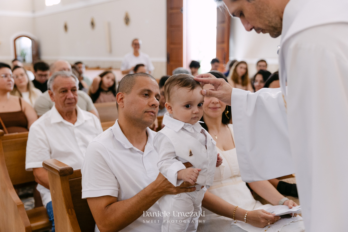 Batizado do Joaquim na Igreja do Socorro em Mogi das Cruzes, registrado por Dani Umezaki. Fotografias de batismo católico com foco na fé, na família e nos momentos mais emocionantes da celebração