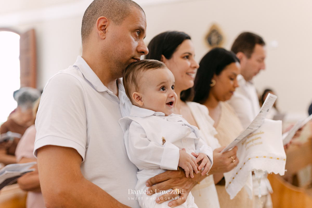 Batizado do Joaquim na Igreja do Socorro em Mogi das Cruzes, registrado por Dani Umezaki. Fotografias de batismo católico com foco na fé, na família e nos momentos mais emocionantes da celebração