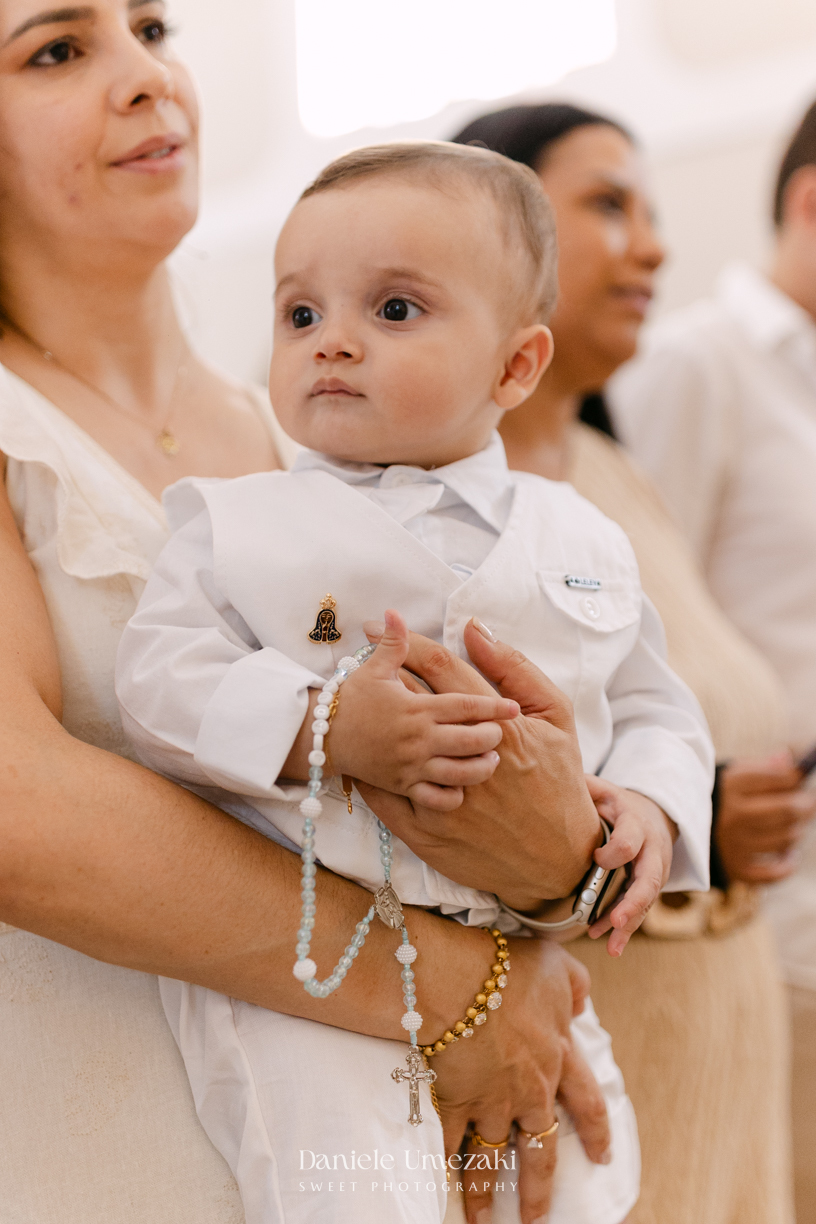 Batizado do Joaquim na Igreja do Socorro em Mogi das Cruzes, registrado por Dani Umezaki. Fotografias de batismo católico com foco na fé, na família e nos momentos mais emocionantes da celebração