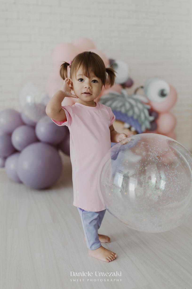 Ensaio infantil da Ayla comemorando 2 anos em estúdio em Mogi das Cruzes, com cenário inspirado na Boo de Monstros S.A. Fotografias leves, divertidas e cheias de personalidade por Dani Umezaki.