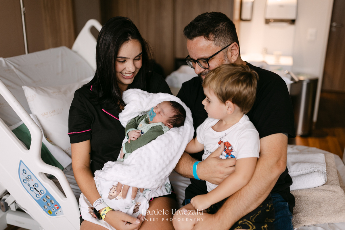 Encontro de irmãos na Maternidade São Luiz Star em São Paulo, registrando o momento em que Bernardo conhece o pequeno Leonardo pela primeira vez, fotografado por Dani Umezaki