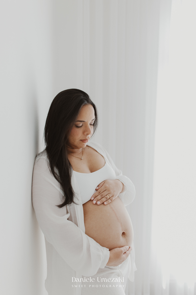 Ensaio gestante em estúdio em Mogi das Cruzes de Cíntia e Rui, registrando a espera pelo bebê com fotografias leves, naturais e atemporais realizadas por Dani Umezaki.