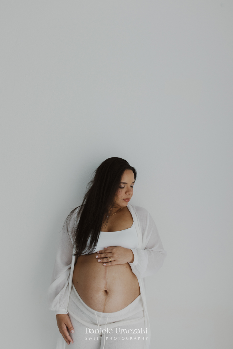 Ensaio gestante em estúdio em Mogi das Cruzes de Cíntia e Rui, registrando a espera pelo bebê com fotografias leves, naturais e atemporais realizadas por Dani Umezaki.